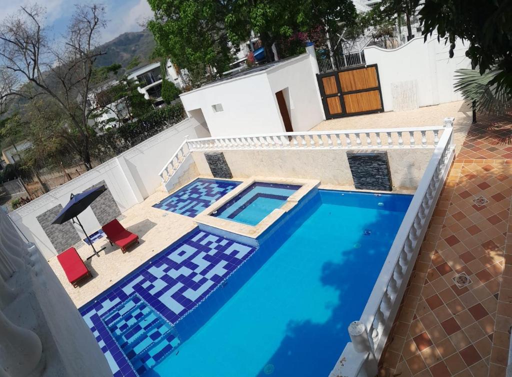 una piscina con 2 sillas y una casa en Hotel Santa Fe del Parque en Santa Fe de Antioquia