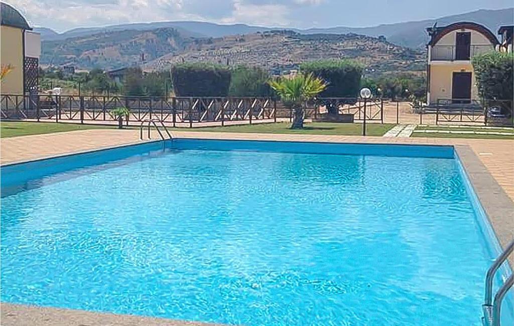 a blue swimming pool with chairs and a building at Casa Loughry in Badolato