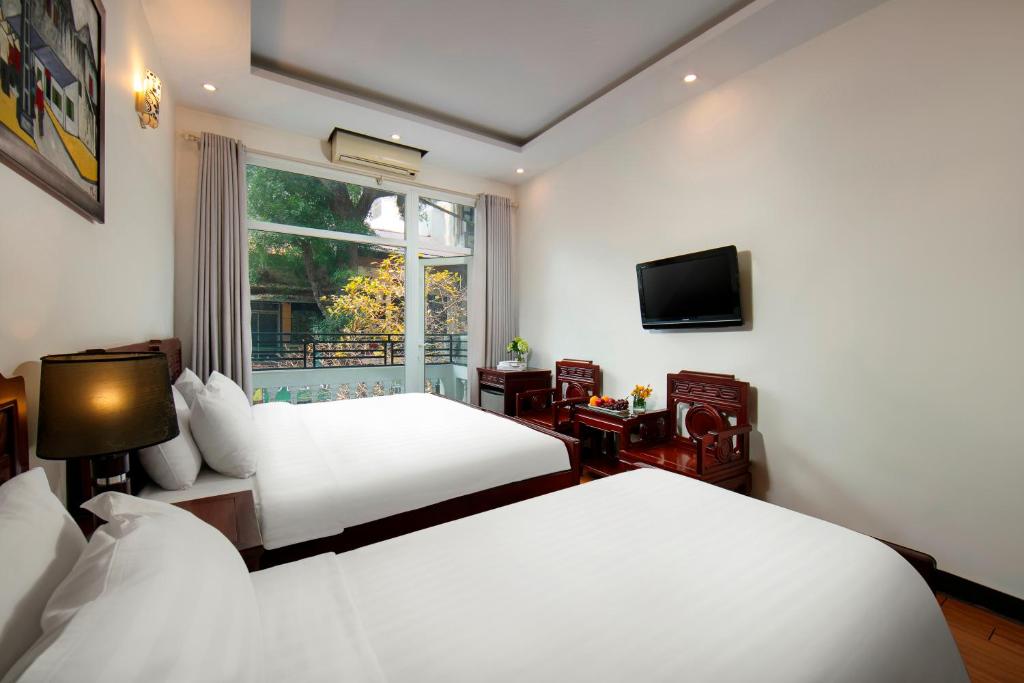 a hotel room with two beds and a window at Hanoi Moonlight Hotel in Hanoi