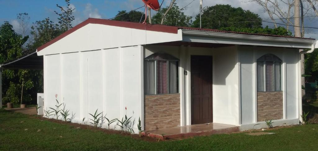 a small white shed with a red roof at Kri's house in Fortuna