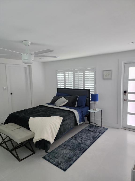 um quarto branco com uma cama e um tapete em JBMANORS em Fort Lauderdale