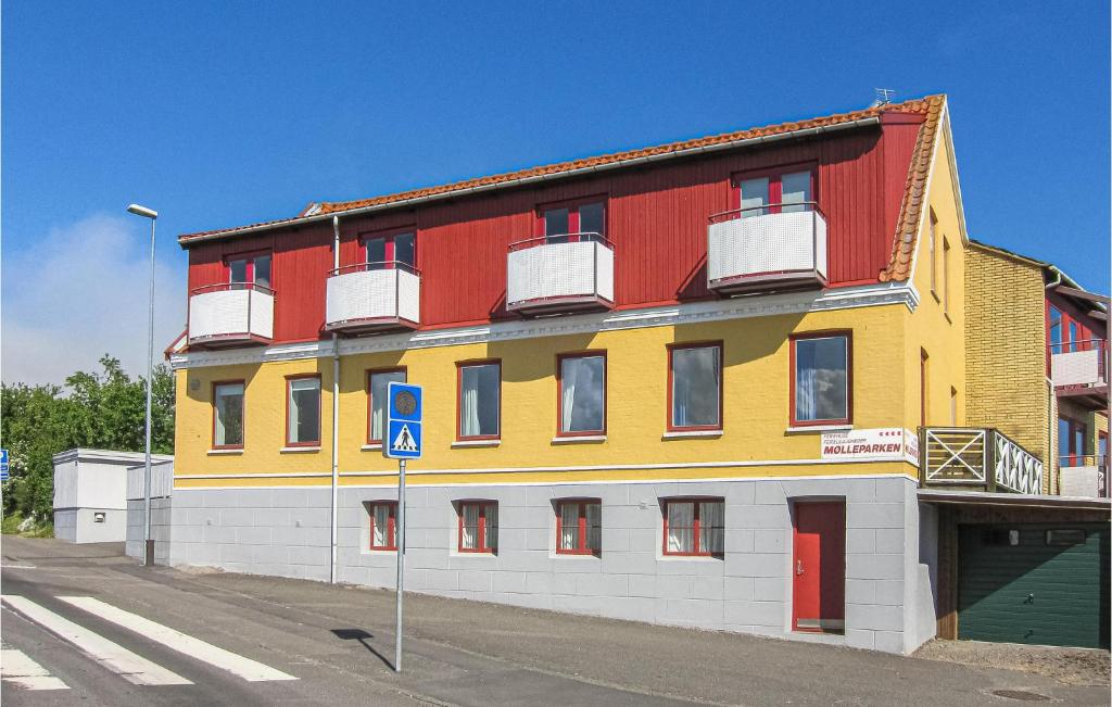 un edificio amarillo y rojo al lado de una calle en Nice Apartment In Gudhjem With Kitchen, en Gudhjem
