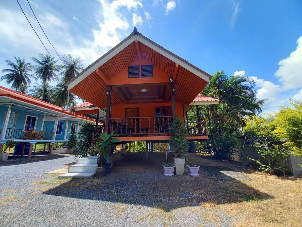 a house with an orange roof with a porch at Patcharin Homestay in Ban Lo Pla Lai (1)