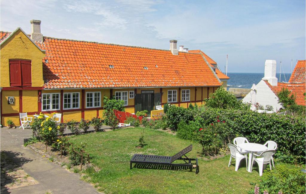 a house with an orange roof and a table and chairs at Beautiful Home In Gudhjem With 2 Bedrooms And Wifi in Gudhjem