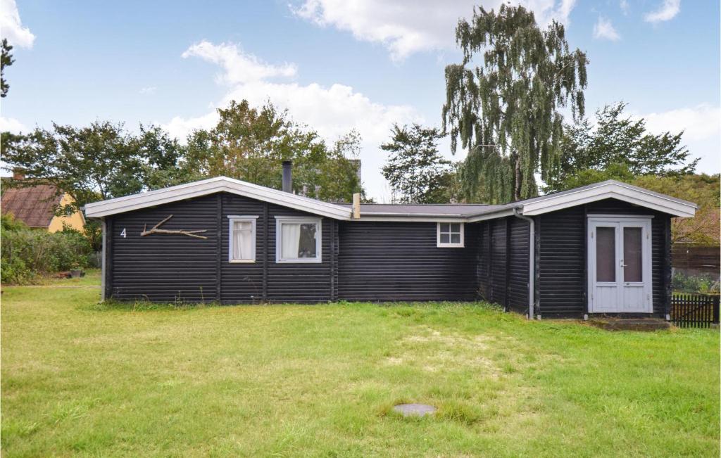 ein kleines schwarzes Haus mit einem Rasenplatz in der Unterkunft Stunning Home In Anholt With Wifi in Anholt