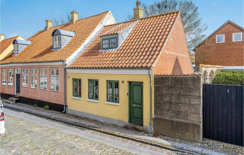 una casa gialla con tetto arancione su una strada di Beautiful Home In Ribe With Wifi a Ribe