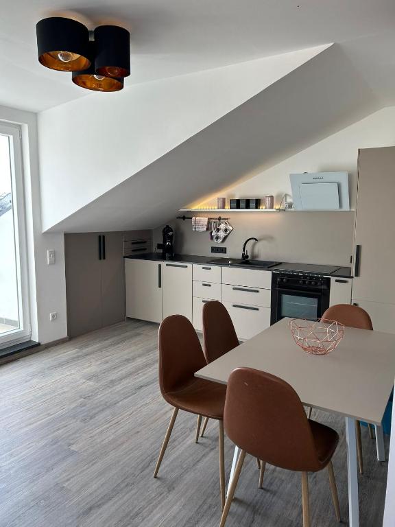 a kitchen with a table and chairs in a room at Timeless - die Ferienwohnung in Wasserburg in Bettnau