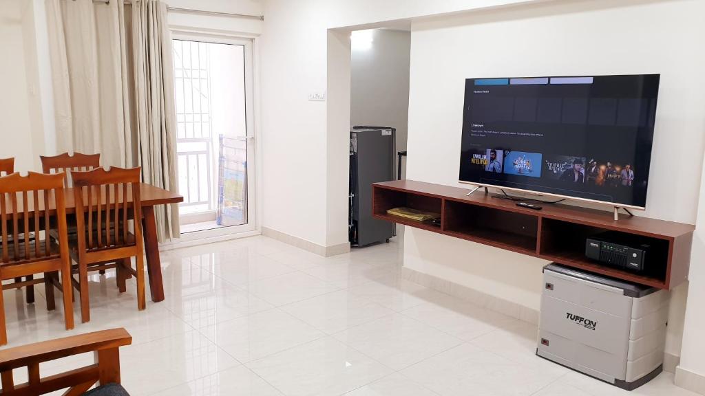 a living room with a flat screen tv on a entertainment center at Chippy Apartments No.544 in Chennai