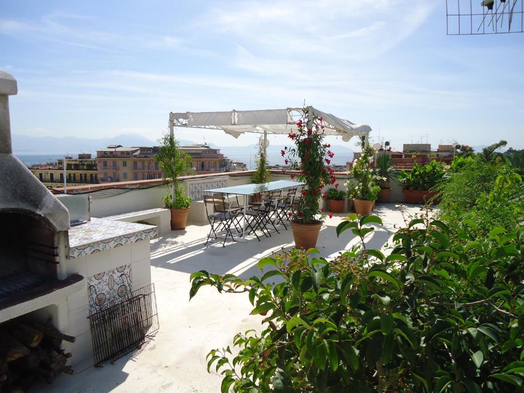 balcón con mesa, sillas y plantas en Relais del mar- luxury penthouse with terrace, en Nápoles