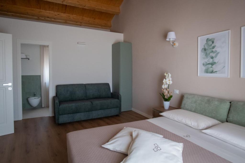 sypialnia z łóżkiem i zieloną kanapą w obiekcie Dimora Donna Dora - Albergo Diffuso w mieście San Martino in Pensilis