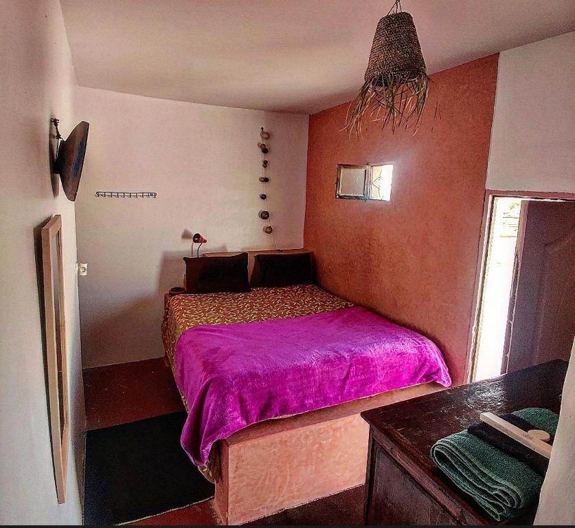 a bedroom with a pink bed in a room at Hippie Chic Room 3 in Sidi Kaouki