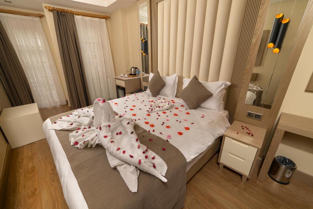 Asilzade Hotel Sirkeci في إسطنبول: غرفة نوم بها سرير كبير وعليها زهور حمراء