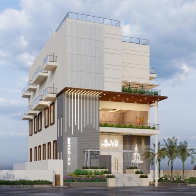 a tall white building with palm trees in front of it at Green Mapple in Muzaffarpur