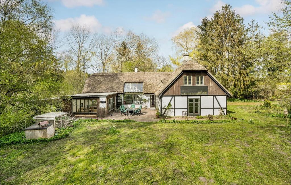 a large house with a thatched roof at Beautiful Home In ster Ulslev With Kitchen in Øster Ulslev