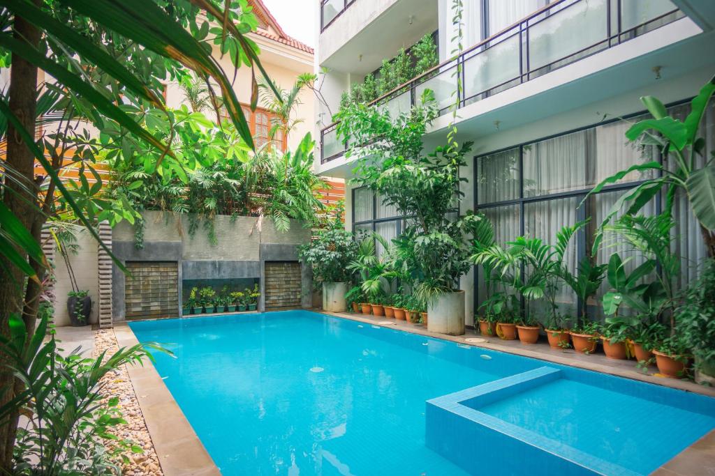 a swimming pool in the middle of a building with plants at Maison Leab in Siem Reap