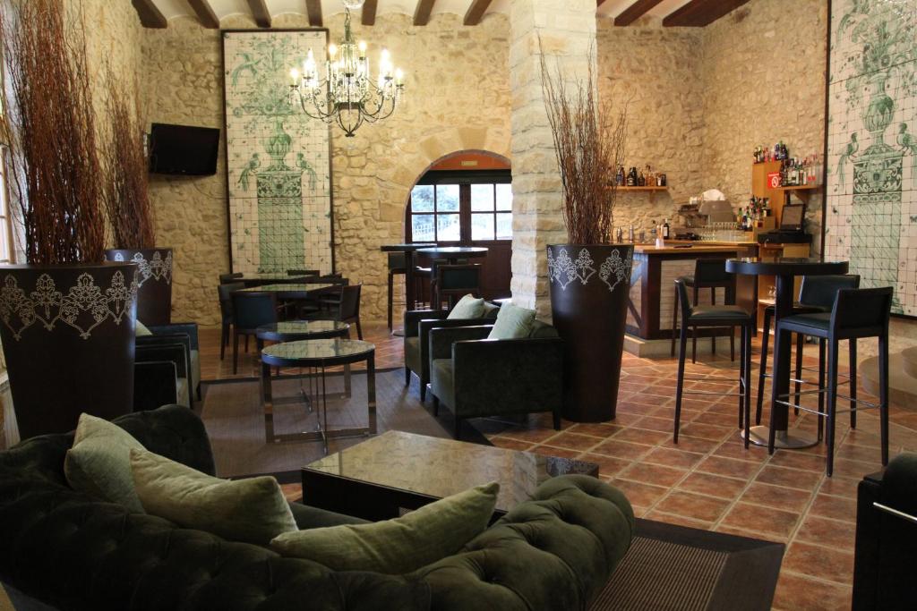 sala de estar con sofá, sillas y bar en Hotel Palacio Dos Olivos, en Galdeano