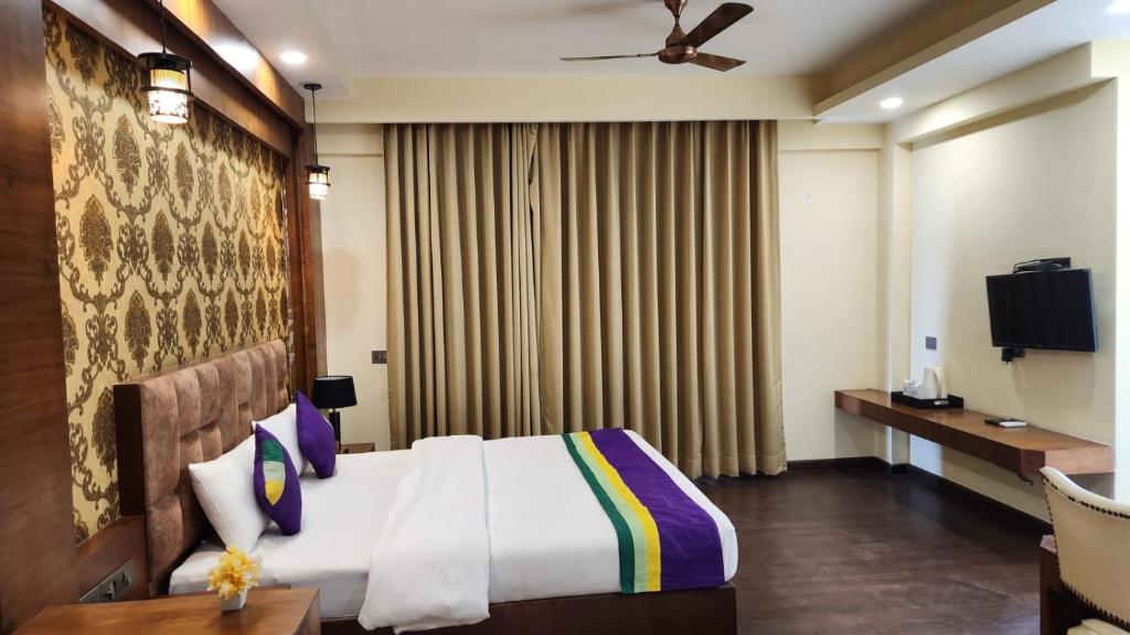 een hotelkamer met een bed en een televisie bij Nearmi Hotels Banquets Medanta IKEA Sector 47 - Gurugram in Gurgaon