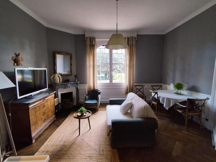 een woonkamer met een bank, een tv en een tafel bij Le Moulleau Appartement 2 chambres - plage à 50m in La Teste-de-Buch