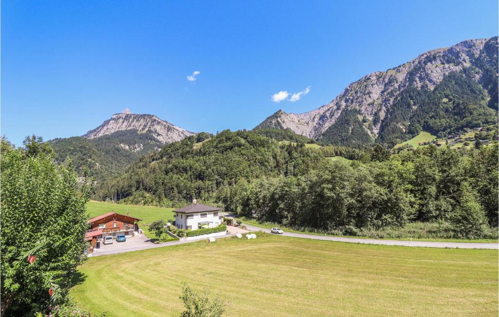 una casa in un campo con montagne sullo sfondo di Gemuetliche Ferienwohnung a Dalaas