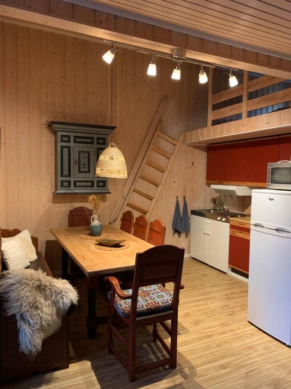 eine Küche mit einem Holztisch mit Stühlen und einem Kühlschrank in der Unterkunft Enok Hytter & Resort in Liagardane