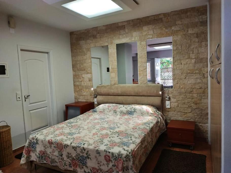 a bedroom with a bed and a stone wall at Heraklion modern studio 40 sq.m. near town center. in Heraklio