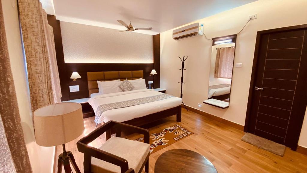 een slaapkamer met een bed, een stoel en een tafel bij Le Shiv Executive Suite in Theni