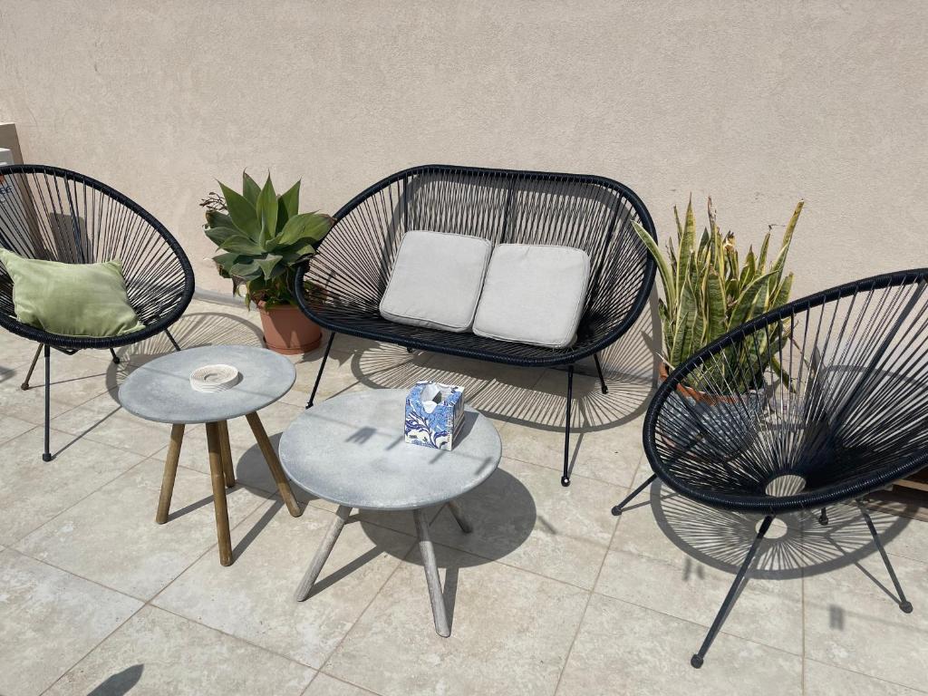 a group of chairs and tables in a room with plants at Hammock Vibes Town House in Sliema