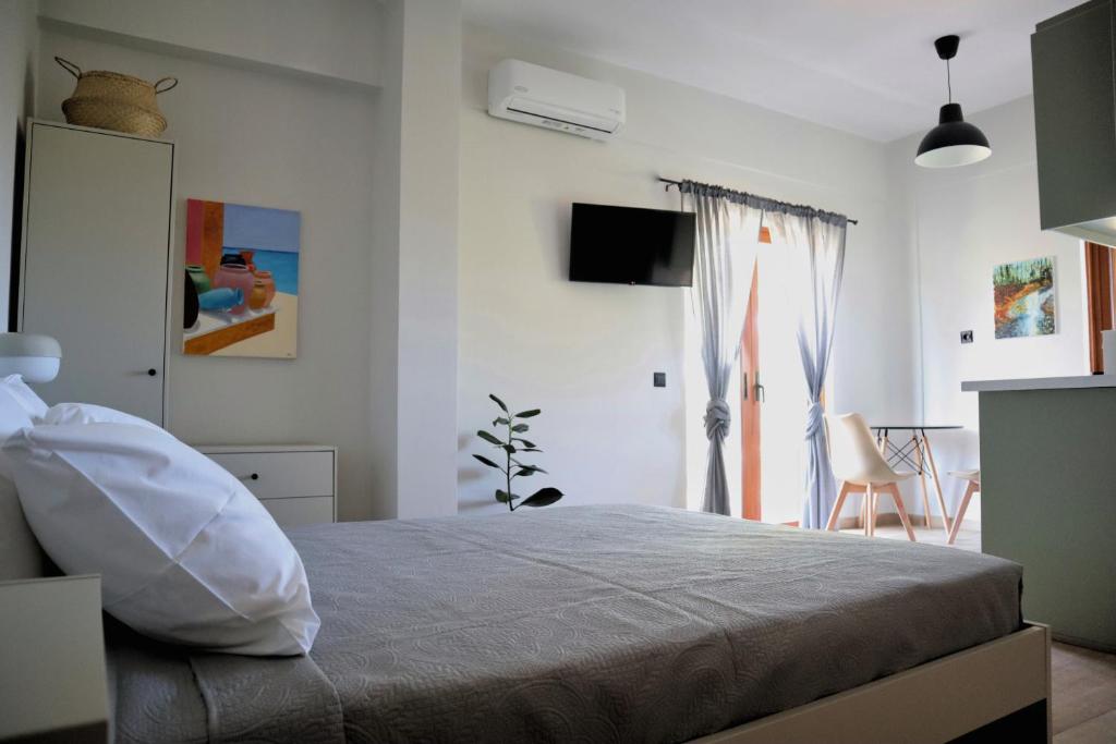 a bedroom with a bed and a room with a tv at Villa Elea Apartments in Spiliá