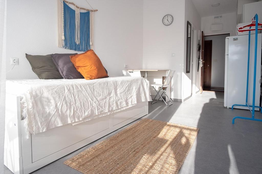 a bedroom with a bed with an orange pillow on it at Casa Carmelina in Torrevieja
