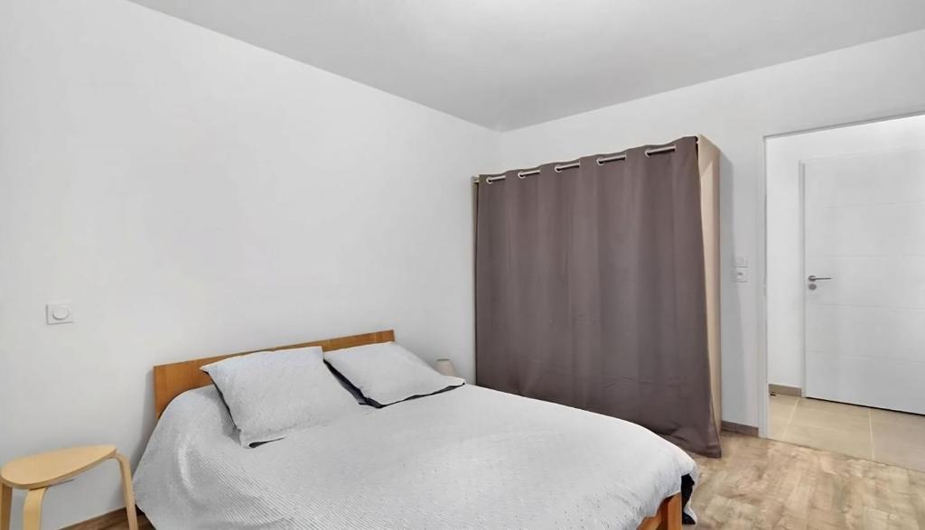 a bedroom with a bed and a gray curtain at Le Lamartine - T3 dans un parc in Frouzins