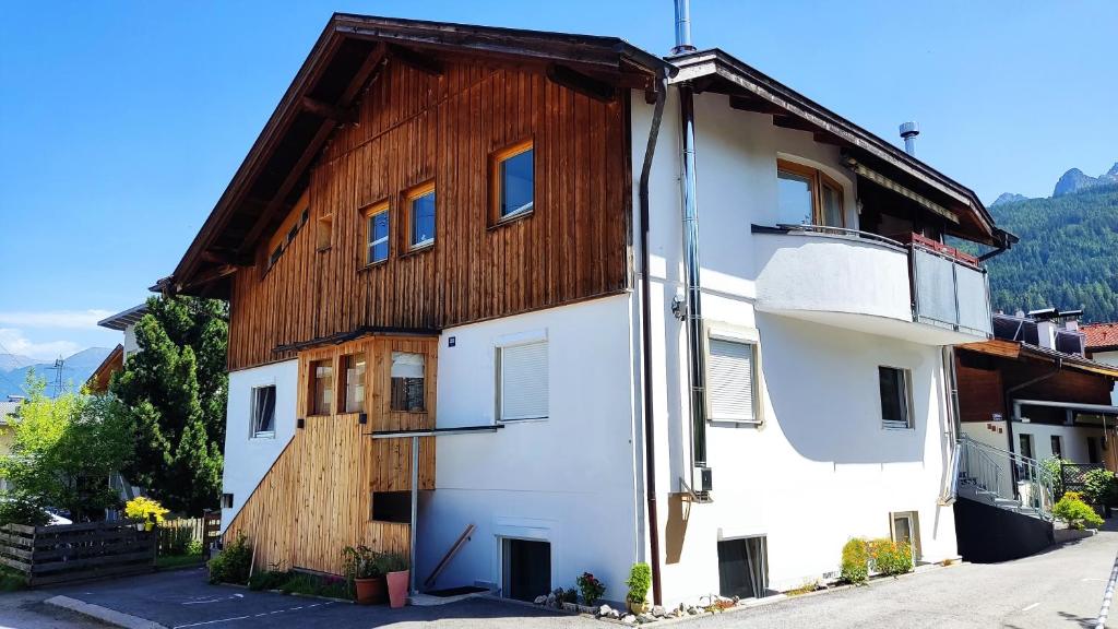 ein weißes Gebäude mit einem Holzdach in der Unterkunft Ferienwohnung Elisa in Innsbruck