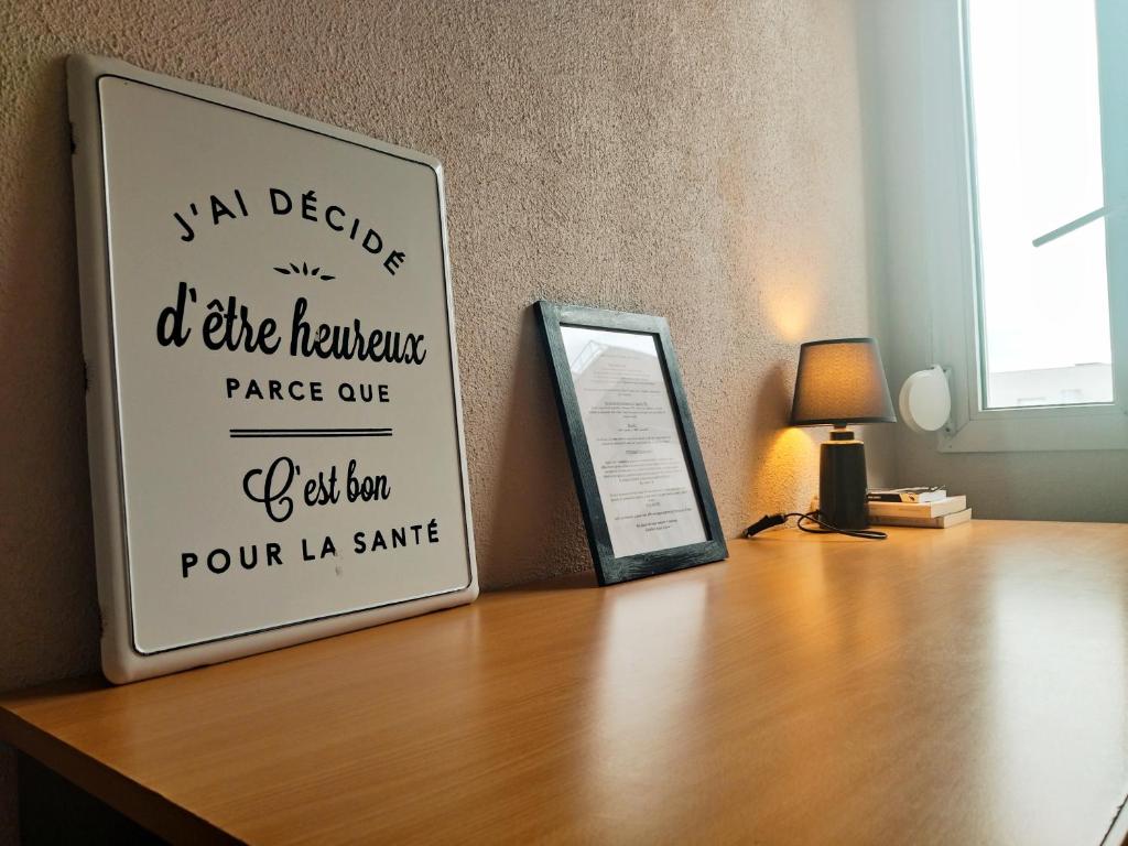 a sign on top of a wooden table with a lamp at Au cœur du grand Lyon à côté de la gare Part-Dieu in Villeurbanne