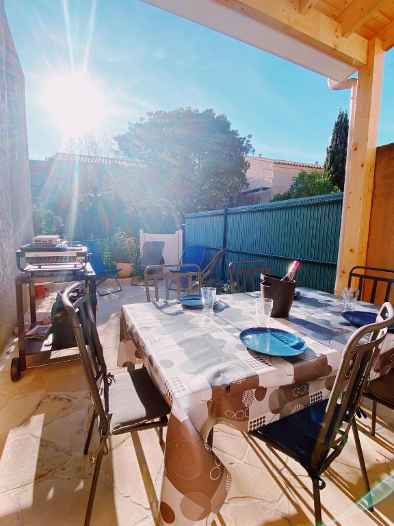 une table et des chaises assises sur une terrasse dans l'établissement Mazet Tahiti Parc, au Lavandou
