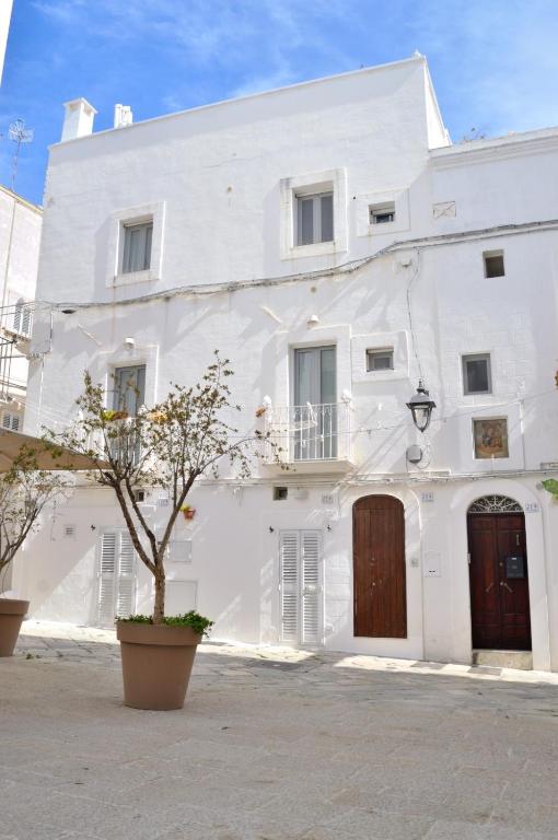 a white building with a tree in front of it at Suite Dolce Vita in Monopoli