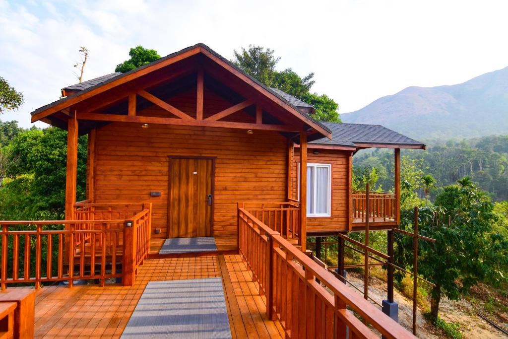 a log cabin with a walkway leading to the front door at River Mist Resort in Mudigere