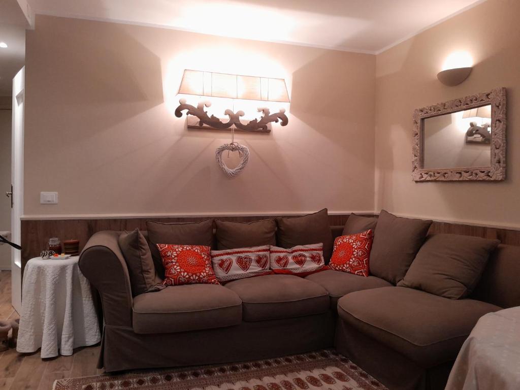 a living room with a brown couch and a mirror at Casa MARIA in Limone Piemonte