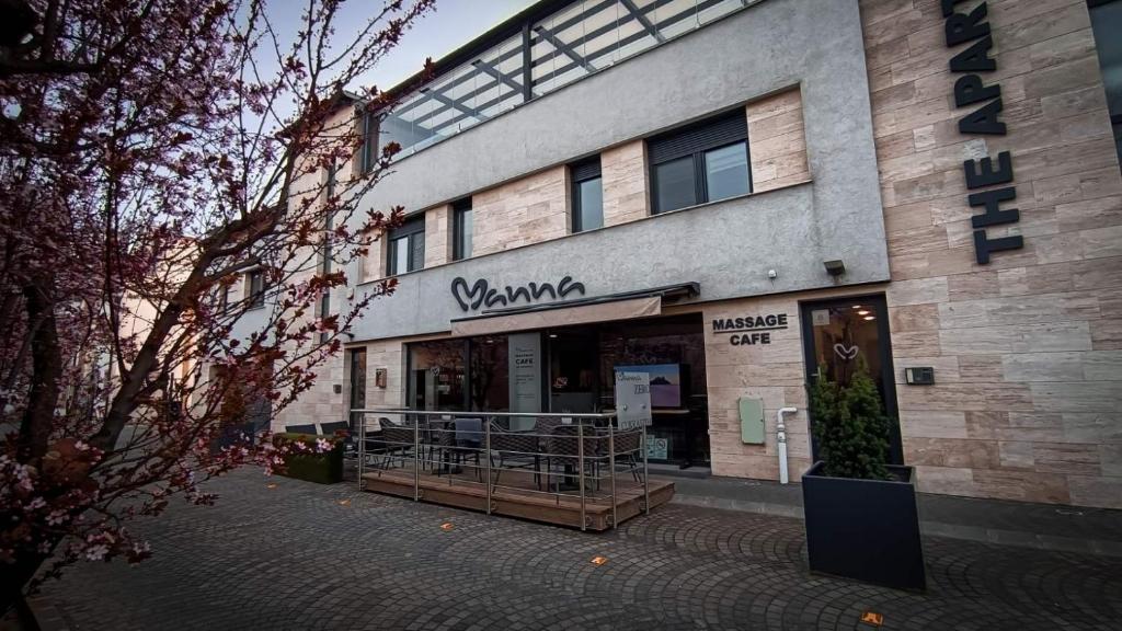 a building with a sign on the front of it at Manna Aparthotel in Jászberény