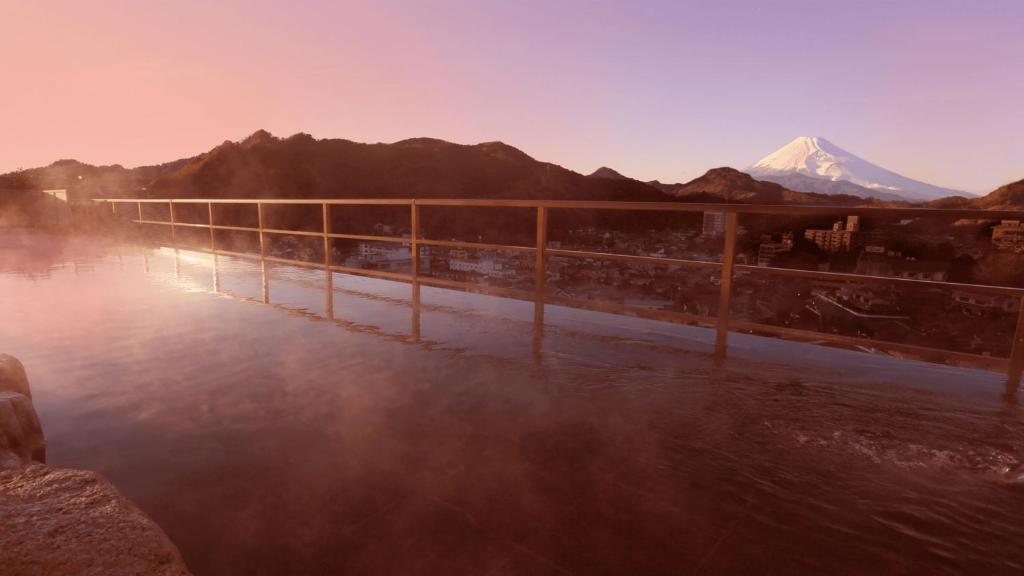 a hot spring with a mountain in the background at New Hakkeien in Izunokuni