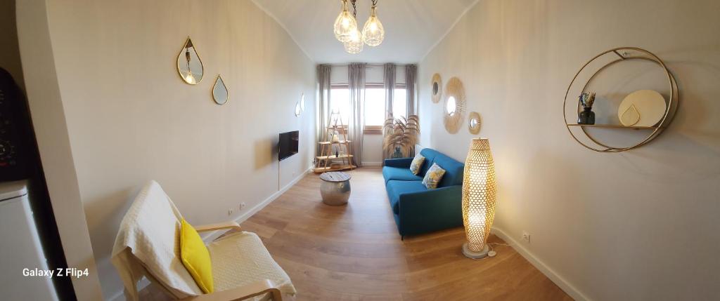 un soggiorno con divano blu e specchio di Charmant studio vue mer / parking / plage à 200m a Bastia