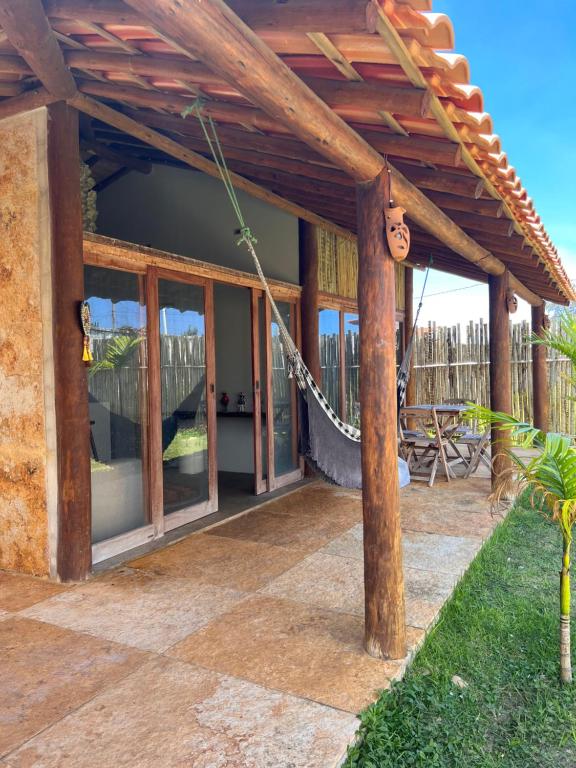 une terrasse d'une maison avec une pergola en bois dans l'établissement Bungalows Morro Do Chapeu Taiba, à Taíba
