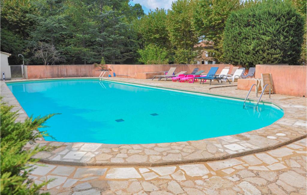 a swimming pool with blue water in a yard at Amazing Apartment In Rustrel With Outdoor Swimming Pool, Wifi And 2 Bedrooms in Rustrel