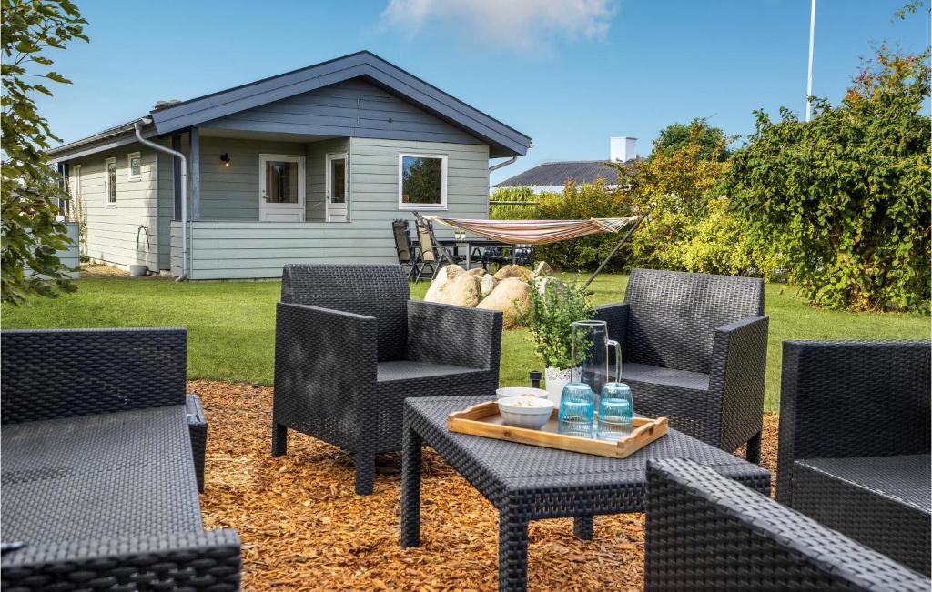 une terrasse avec des chaises et une table ainsi qu'une maison dans l'établissement 2 Bedroom Cozy Home In Kerteminde, à Kerteminde