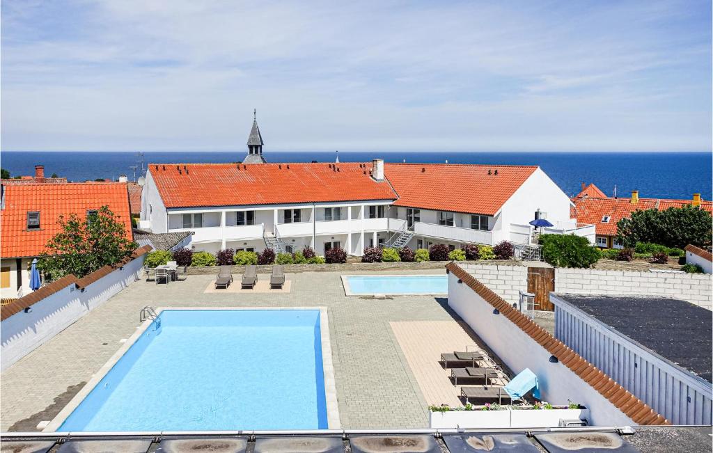 uma casa com piscina em frente ao oceano em Stunning Apartment In Gudhjem With Outdoor Swimming Pool em Gudhjem