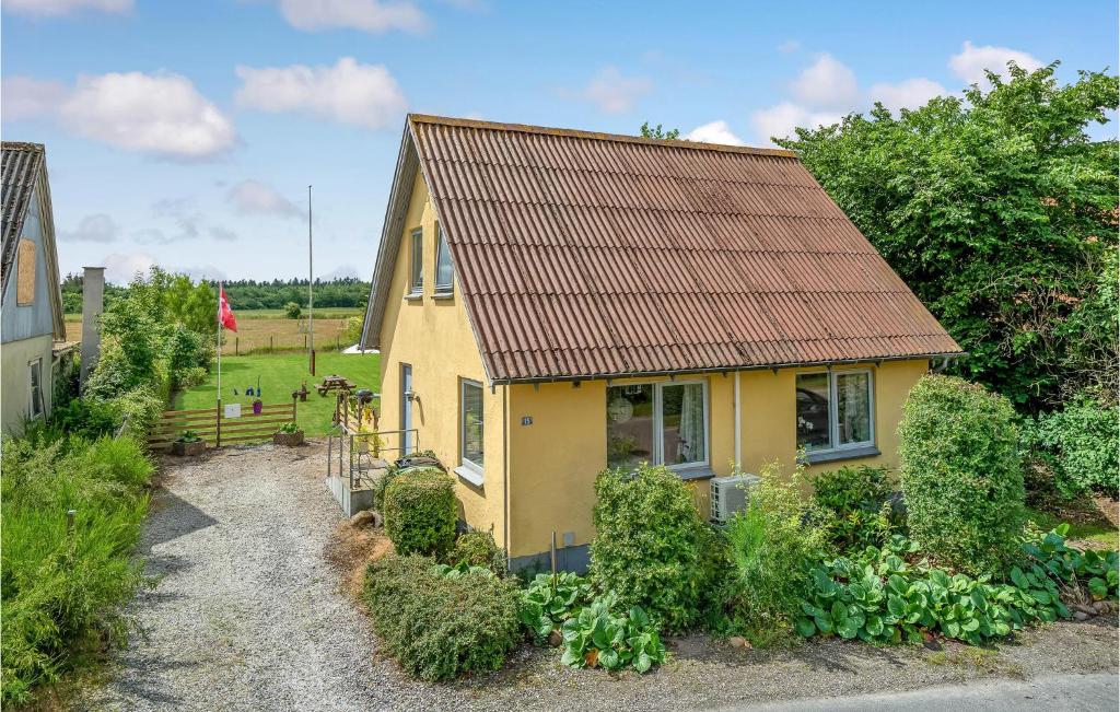 une maison jaune avec un toit rouillé dans l'établissement Stunning Home In Ulfborg With Kitchen, à Ulfborg