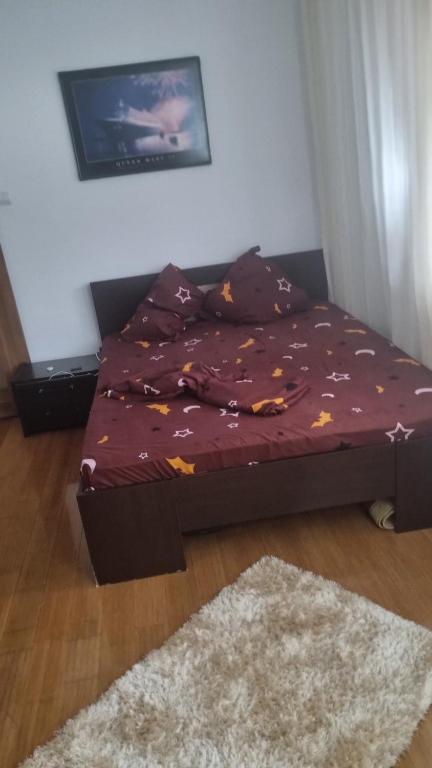 ein kleines Bett in einem Zimmer mit einer lila Tagesdecke in der Unterkunft Apartament Ema in Mangalia