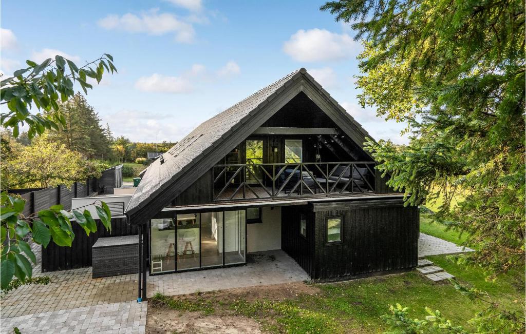 una casa negra con techo de gambrel en Amazing Apartment In Blokhus With Wifi, en Blokhus