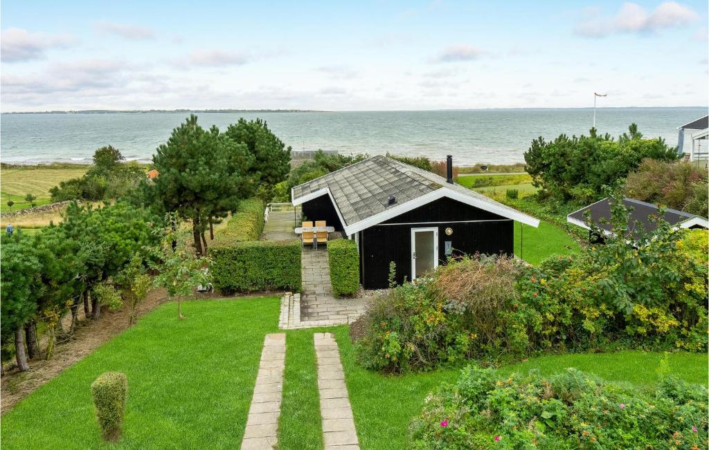 a small black house with a view of the ocean at Beautiful Home In Faaborg With Kitchen in Fåborg