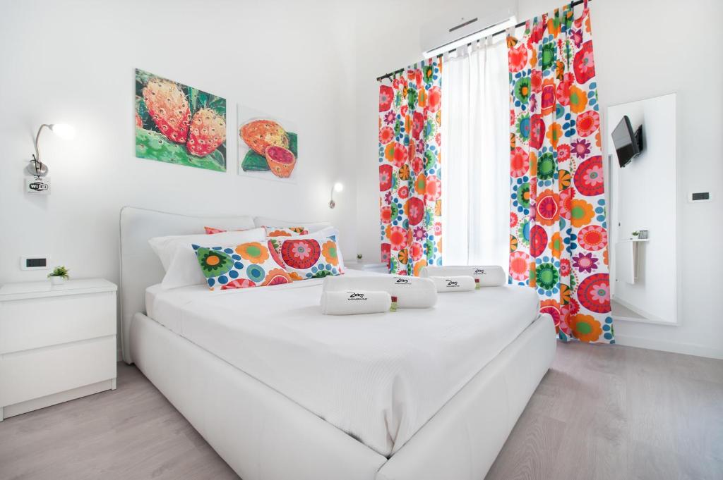 ein weißes Schlafzimmer mit einem weißen Bett mit zwei Laptops darauf in der Unterkunft Room & Breakfast Zero in Palermo