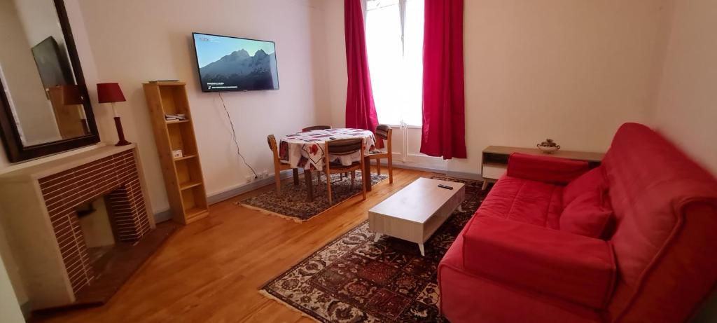 sala de estar con sofá rojo y mesa en MAIRIE, Apart 50 m2 , Lumineux , Rénové , 4 Pers., en Le Havre