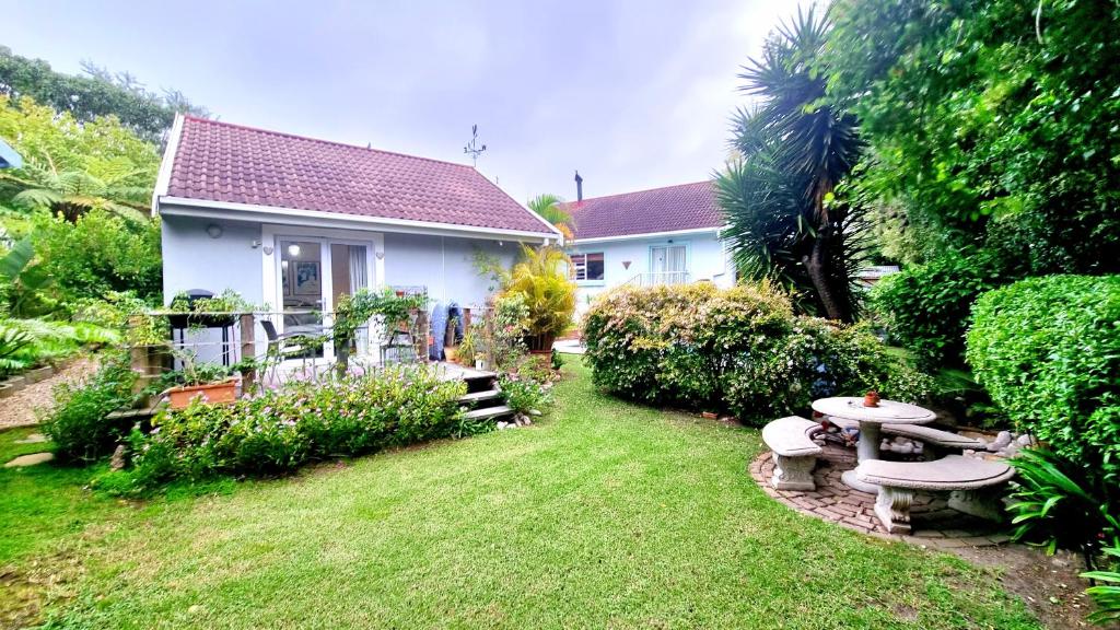 una casa con patio con mesa de picnic y césped en Crescent cottage, en Knysna